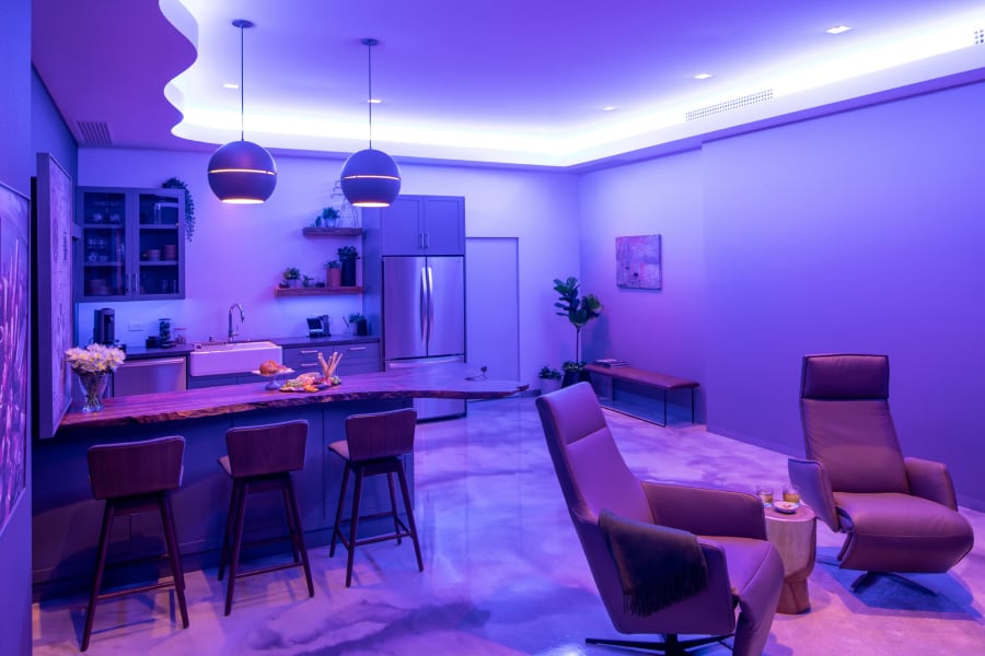 A showroom kitchen cast in purple lighting.