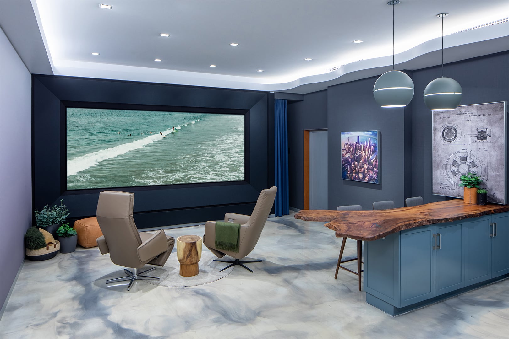 In a cool white-light setting, the Global Wave Showroom presents a captivating ocean view on its theater screen, while luxurious chairs face the display, and a meticulously crafted wooden island takes center stage.